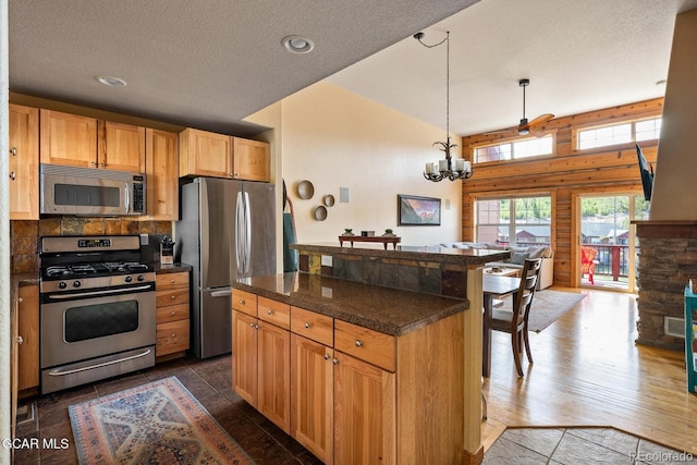220 Reunion Ct, Fraser, CO 80442 - kitchen with appliances with stainless steel finishes, a chandelier, a kitchen island, a textured ceiling, and a kitchen bar