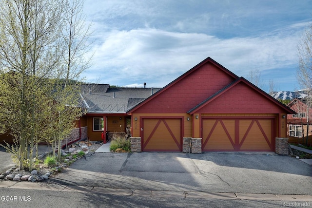 220 Reunion Ct, Fraser, CO 80442 - view of front facade with stone siding, a garage, driveway, and a shingled roof
