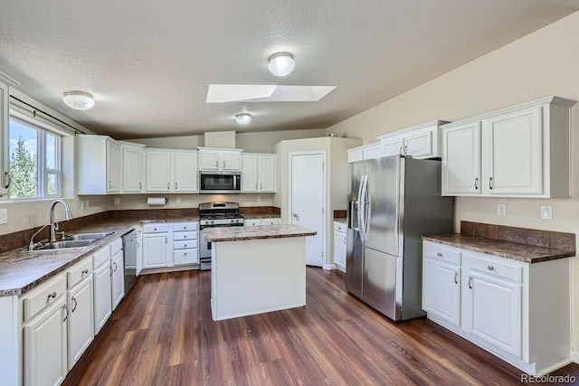 kitchen with white cabinetry, a kitchen island, dark wood-type flooring, and appliances with stainless steel finishes