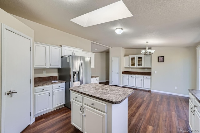 kitchen with stainless steel fridge with ice dispenser, dark hardwood / wood-style flooring, white cabinets, and a kitchen island