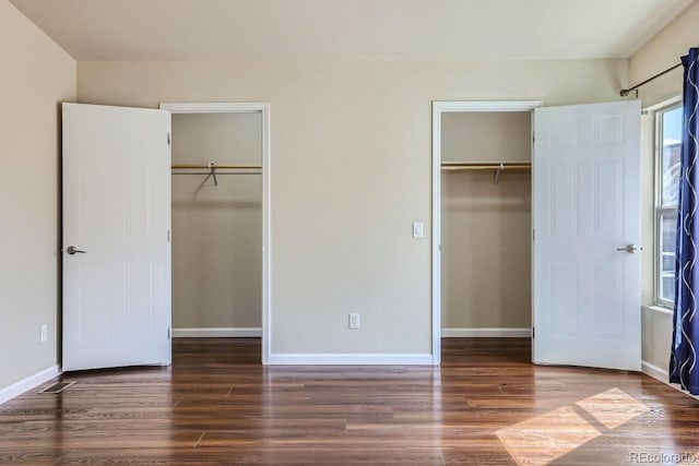 unfurnished bedroom with dark hardwood / wood-style flooring