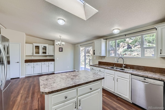 kitchen featuring dark hardwood / wood-style floors, a kitchen island, white cabinetry, and appliances with stainless steel finishes