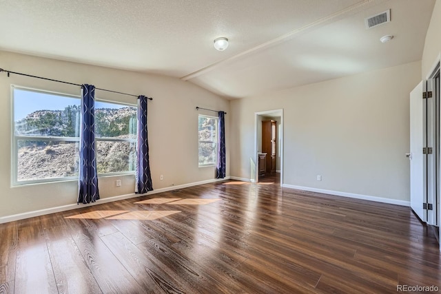 unfurnished room with a textured ceiling, dark hardwood / wood-style flooring, and lofted ceiling