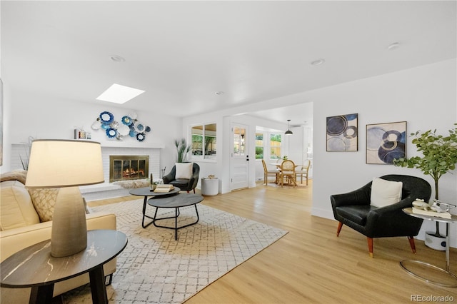 6643 W Roxbury Pl, Littleton, CO 80128 - living area featuring light wood-style flooring, a skylight, and a fireplace
