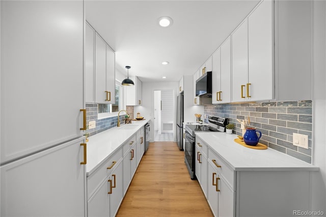 6643 W Roxbury Pl, Littleton, CO 80128 - kitchen featuring stainless steel appliances, range hood, recessed lighting, backsplash, and light wood-type flooring