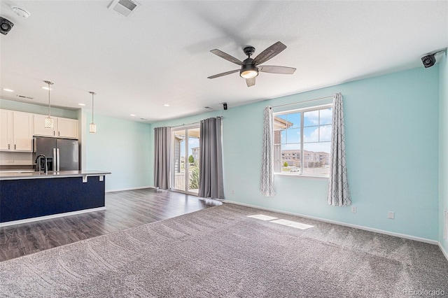 unfurnished living room with a ceiling fan, recessed lighting, baseboards, visible vents, and carpet floors