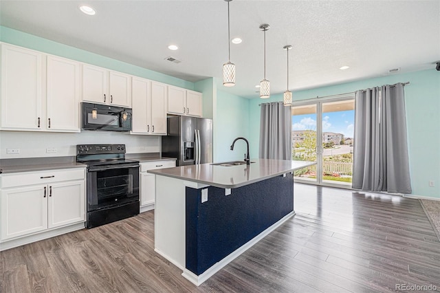 kitchen with a sink, wood finished floors, black appliances, recessed lighting, and white cabinets