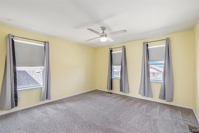 carpeted empty room featuring ceiling fan, baseboards, and visible vents