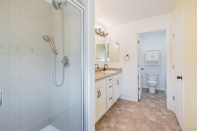 bathroom with vanity, toilet, baseboards, and a shower stall