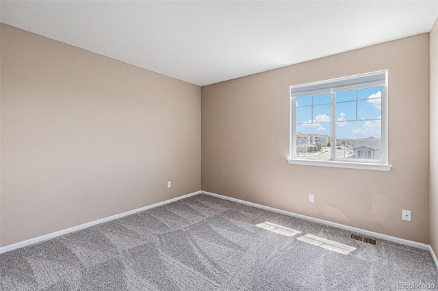 carpeted empty room featuring visible vents and baseboards