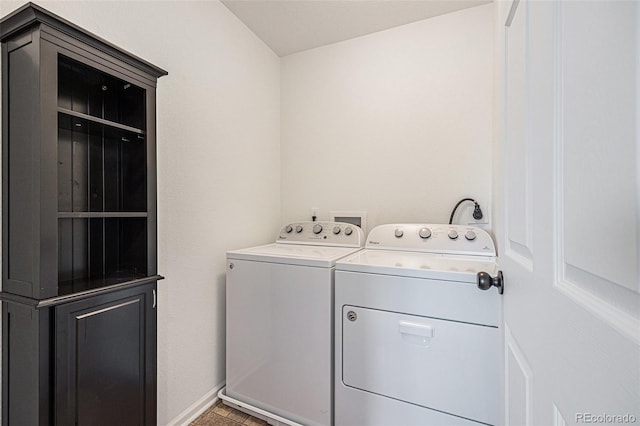 clothes washing area with washing machine and dryer and baseboards