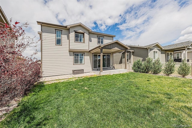 rear view of house with a patio, fence, and a lawn