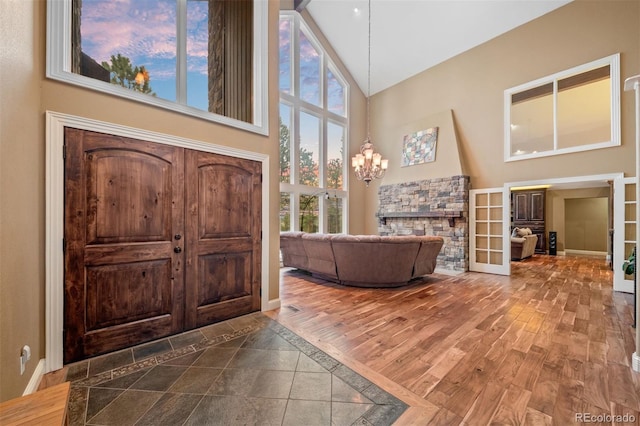 29210 Northstar Ln, Evergreen, CO 80439 - entrance foyer featuring high vaulted ceiling, french doors, a chandelier, and wood finished floors