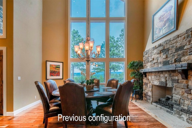 29210 Northstar Ln, Evergreen, CO 80439 - dining space featuring a high ceiling, wood finished floors, a chandelier, and a stone fireplace