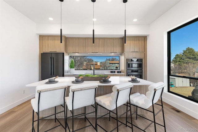 kitchen with stainless steel appliances, visible vents, light countertops, a center island, and modern cabinets