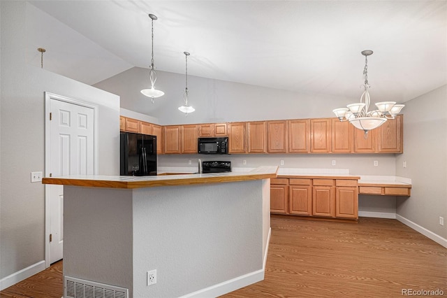 5214 S Tibet St, Aurora, CO 80015 - kitchen with black appliances, vaulted ceiling, light countertops, light wood finished floors, and a chandelier