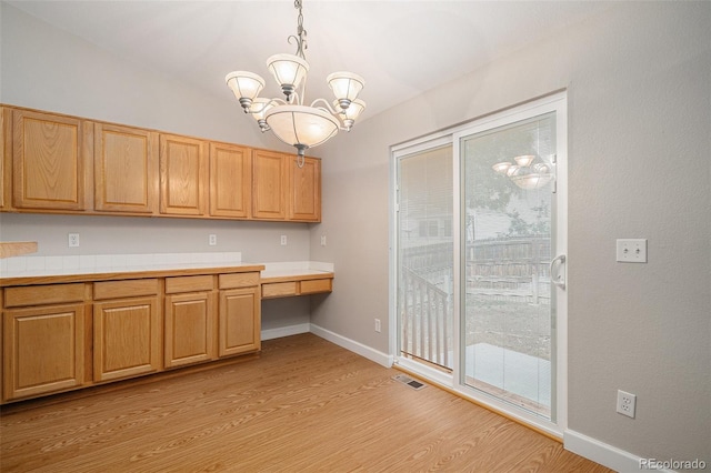 5214 S Tibet St, Aurora, CO 80015 - kitchen with light wood-style floors, a chandelier, light countertops, baseboards, and hanging light fixtures