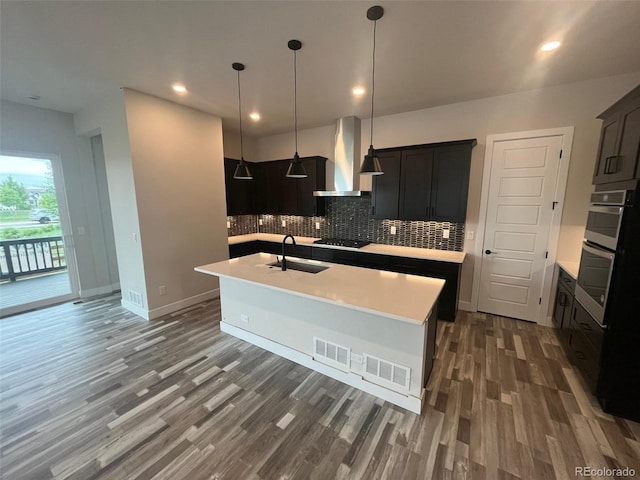1613 Winter Glow Dr, Windsor, CO 80550 - kitchen with wall chimney exhaust hood, a sink, light countertops, wood finished floors, and recessed lighting