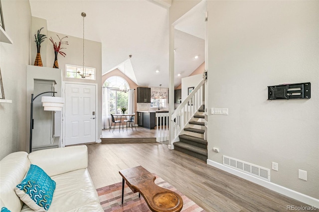 3612 Rosewalk Cir, Highlands Ranch, CO 80129 - living room with a chandelier, wood finished floors, high vaulted ceiling, and stairway
