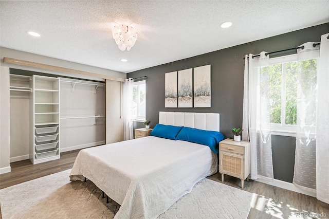3612 Rosewalk Cir, Highlands Ranch, CO 80129 - bedroom with multiple windows, wood finished floors, a closet, a textured ceiling, and recessed lighting