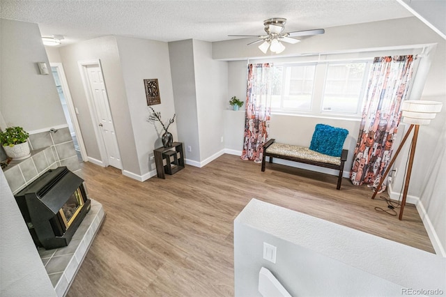 3612 Rosewalk Cir, Highlands Ranch, CO 80129 - sitting room with ceiling fan, a wood stove, wood finished floors, a textured ceiling, and heating unit