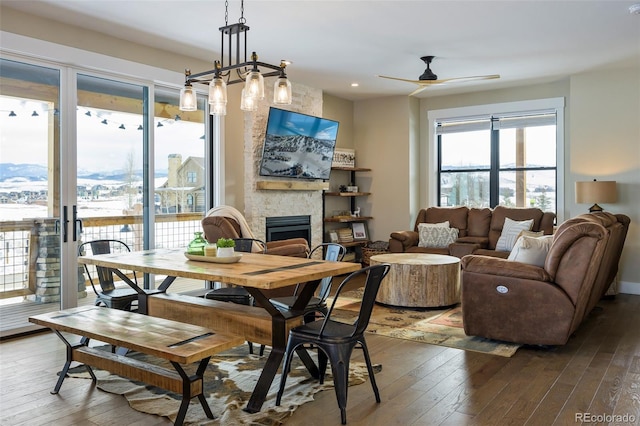 dining space featuring ceiling fan, a fireplace, a mountain view, and hardwood / wood-style floors