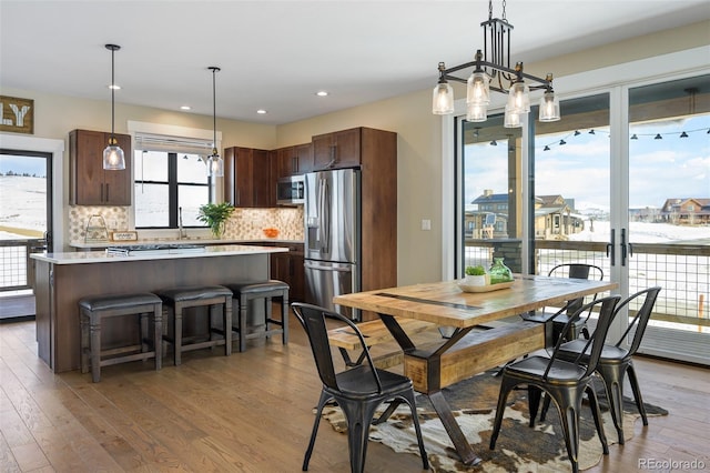 dining area with light wood-type flooring and recessed lighting