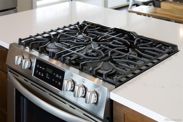 details with stainless steel gas stove and light countertops