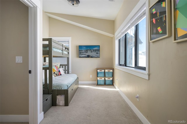 hallway with carpet floors, baseboards, and vaulted ceiling