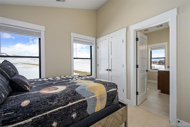 bedroom featuring light carpet, visible vents, and baseboards