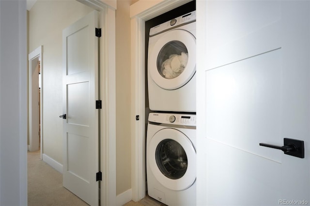 clothes washing area featuring light colored carpet and stacked washing maching and dryer