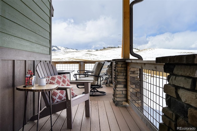 snow covered deck featuring a mountain view