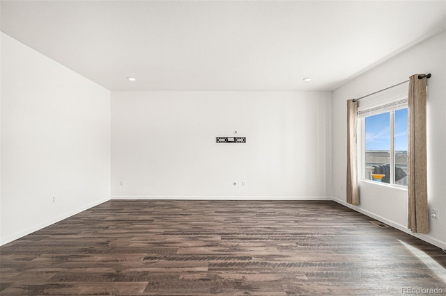 unfurnished room with dark hardwood / wood-style flooring