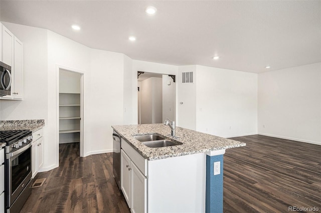 kitchen with white cabinetry, stainless steel appliances, sink, and an island with sink