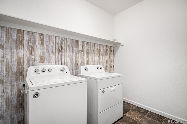 laundry room featuring separate washer and dryer and wooden walls