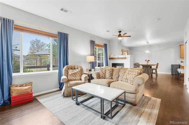 12973 Grant Cir E Unit A, Thornton, CO 80241 - living area featuring ceiling fan, wood finished floors, a glass covered fireplace, and baseboards