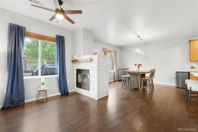 12973 Grant Cir E Unit A, Thornton, CO 80241 - living room featuring dark wood finished floors, healthy amount of natural light, a ceiling fan, and a fireplace