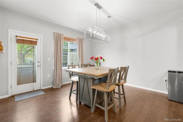 12973 Grant Cir E Unit A, Thornton, CO 80241 - dining area with a chandelier, dark wood-style flooring, and baseboards