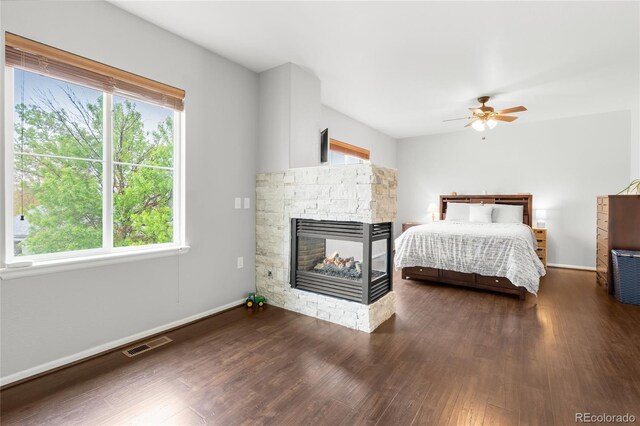 12973 Grant Cir E Unit A, Thornton, CO 80241 - bedroom featuring multiple windows, wood finished floors, and a stone fireplace