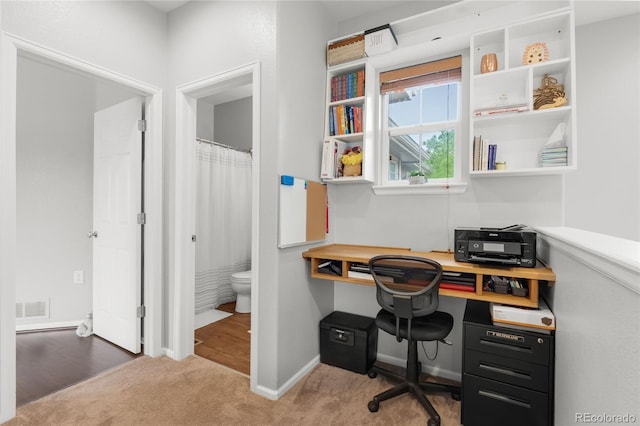 12973 Grant Cir E Unit A, Thornton, CO 80241 - home office featuring carpet flooring, built in desk, and baseboards