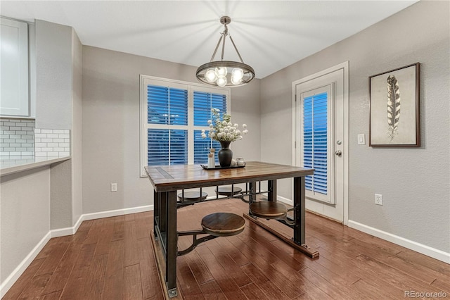 dining area with an inviting chandelier, wood finished floors, and baseboards