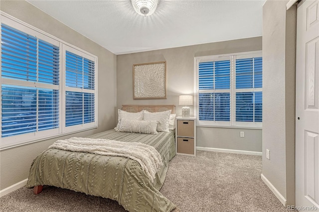 bedroom featuring carpet floors, baseboards, a textured ceiling, and a textured wall