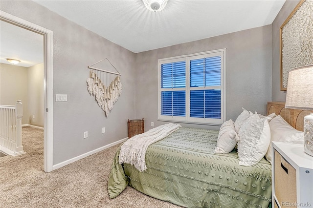 bedroom with a textured wall, carpet floors, and baseboards