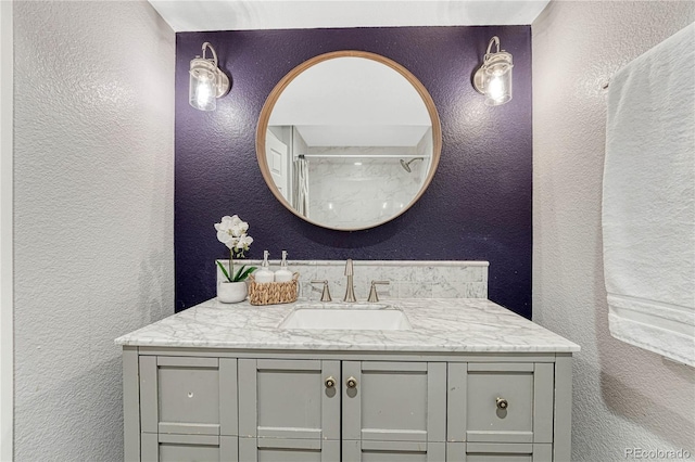 bathroom featuring a textured wall and vanity