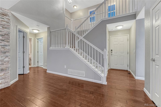 stairs featuring visible vents, baseboards, and hardwood / wood-style floors