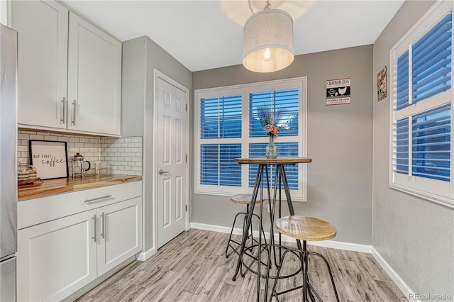 dining room featuring baseboards and light wood-style floors