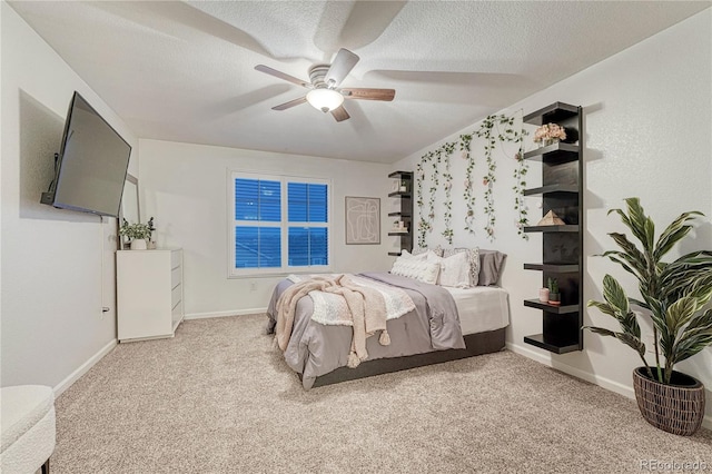 carpeted bedroom featuring a ceiling fan, a textured ceiling, and baseboards