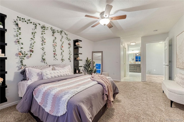 bedroom featuring carpet flooring, connected bathroom, a textured ceiling, ceiling fan, and baseboards