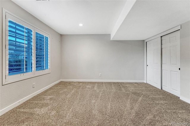 unfurnished bedroom featuring a closet, carpet flooring, and baseboards