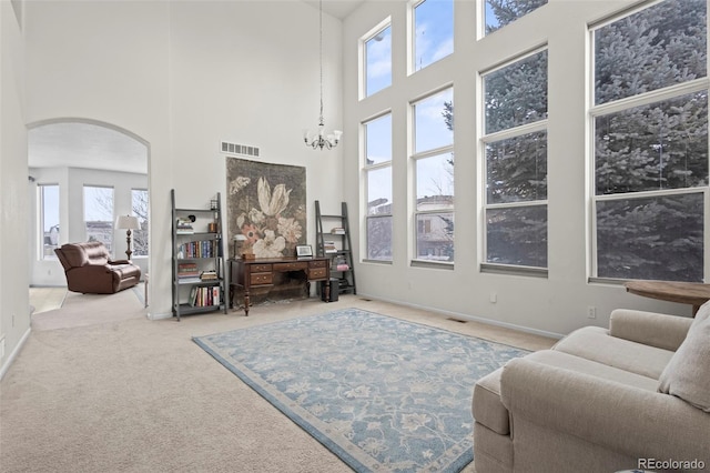 sitting room featuring a chandelier, carpet, and a high ceiling